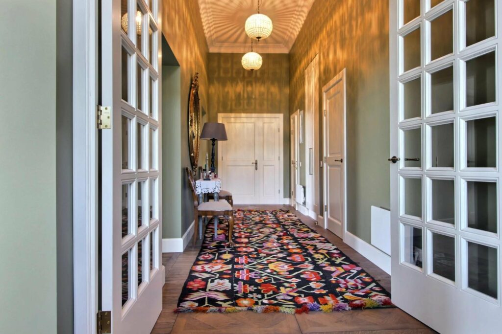 hallway with colorful rug and open french doors