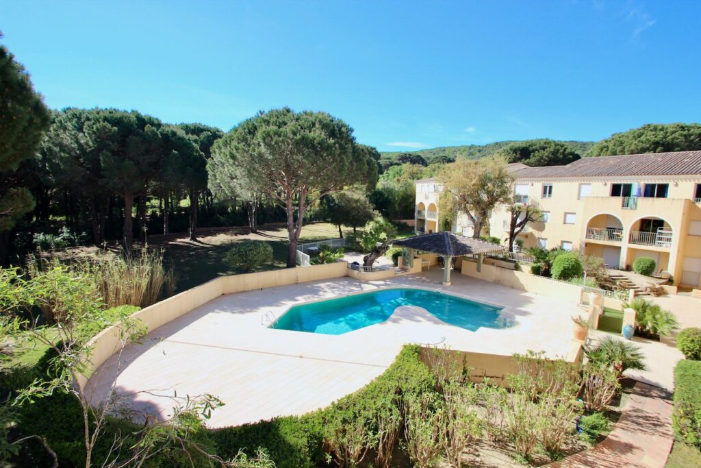 backyard of apartment for sale in saint tropez with a pool and a large garden area