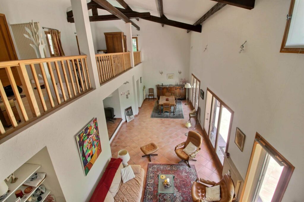 large open living area of house with provencal style tile floors and mezzanine