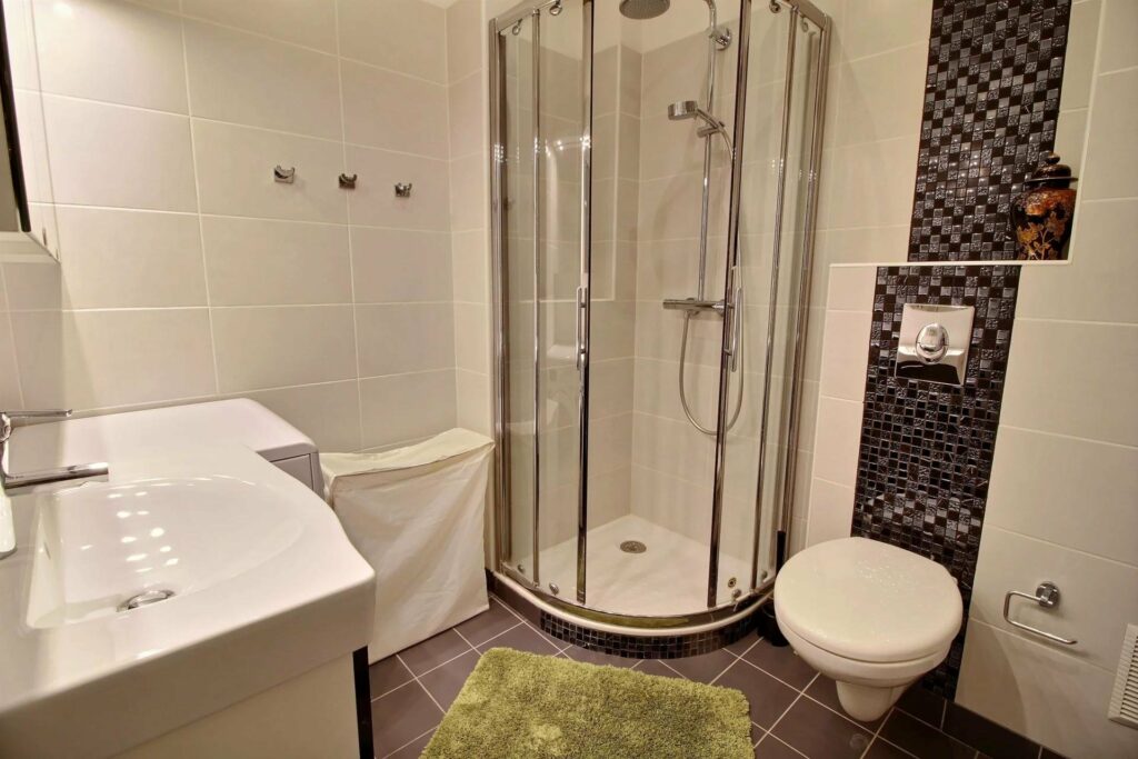 bathroom with standing shower and tile floors with small rug
