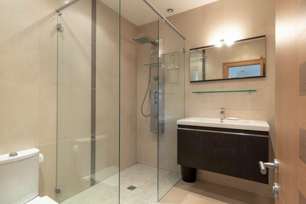 bathroom with glass standing shower and dark wood cabinet