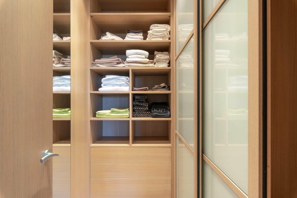 large walk in closet with light wood cabinets