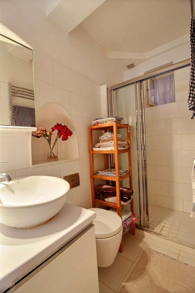 bathoom with white round sink and standing shower