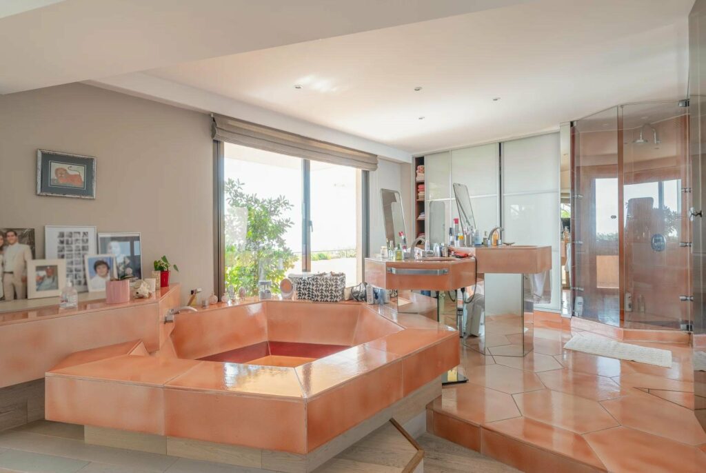 bathroom with large orange bathtub and sliding glass doors to terrace