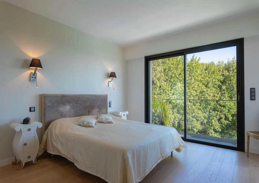bedroom with large queen size bed and large glass door to terrace