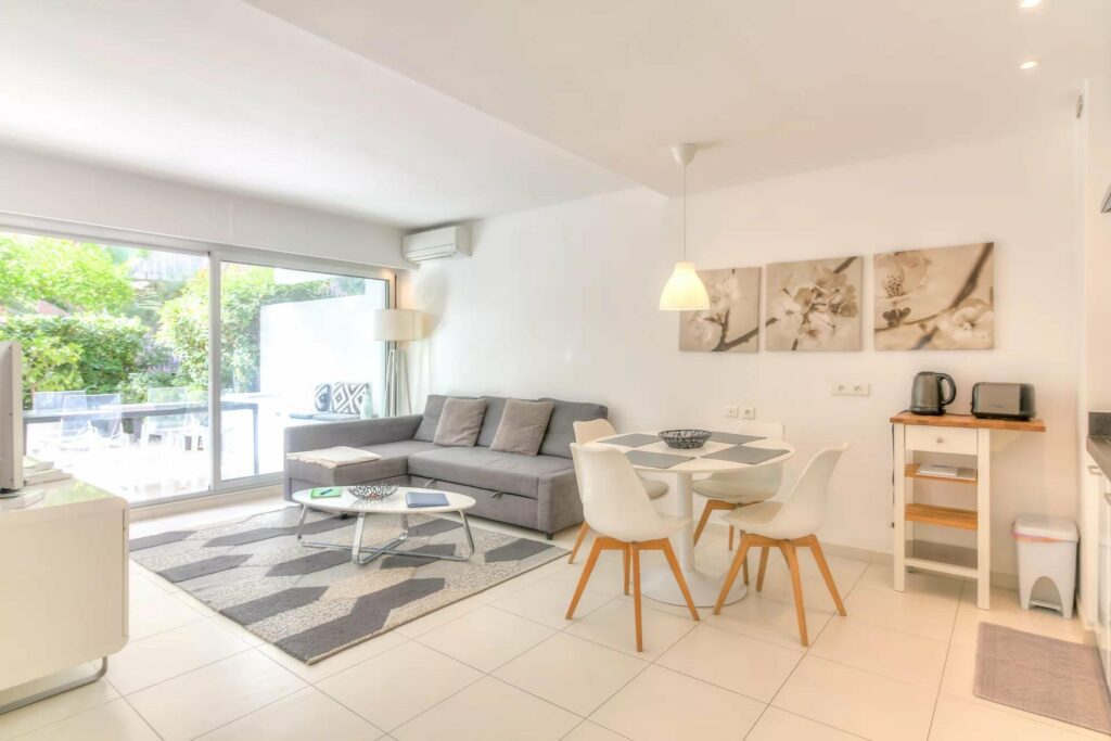 living room in menton aparment with grey couch and white tile floors