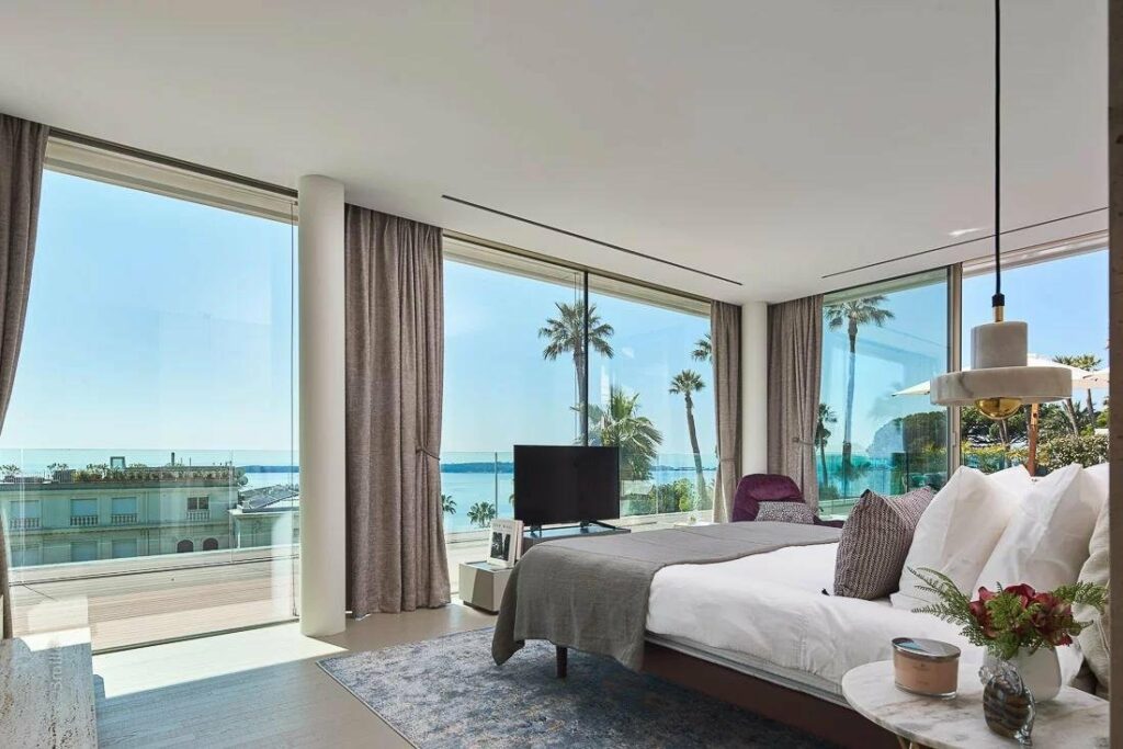 bedroom with sea view and large bed and grey rug