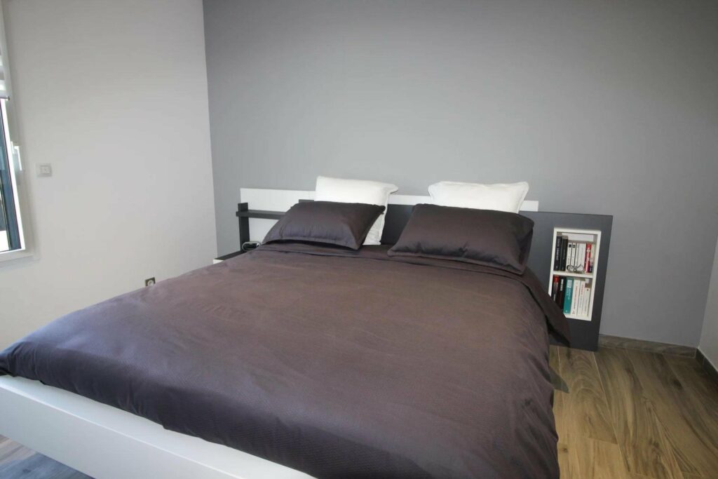 bedroom with dark sheets and grey wall
