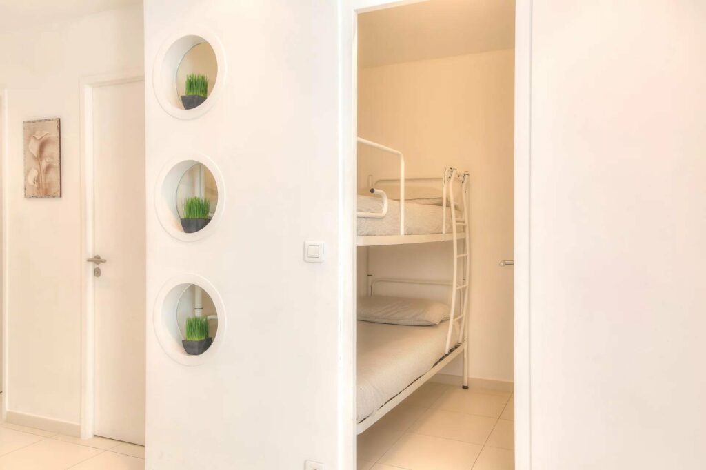 bedroom with white bunk beds and white tile floors