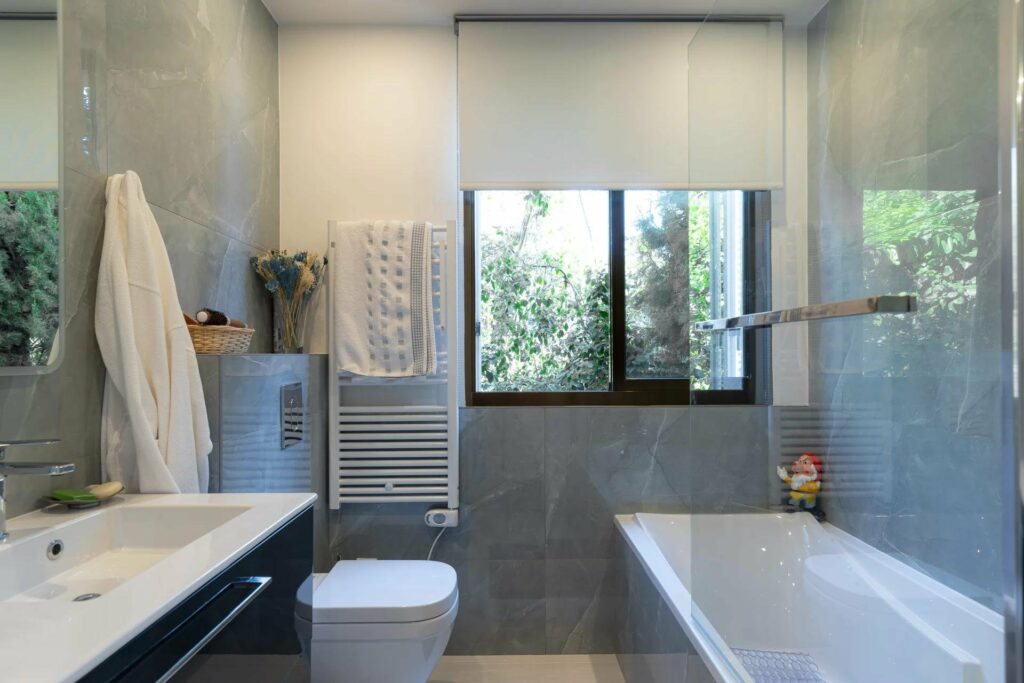bathroom with grey tile walls andd white bathtub