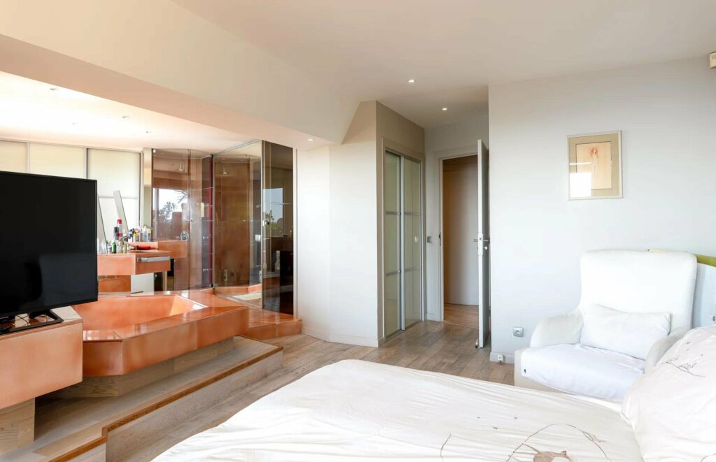 bedroom with exposed orange bathtub and white walls