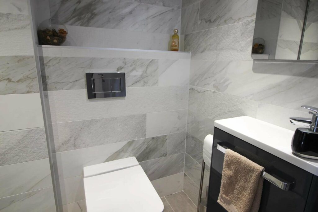bathroom with marble walls and white toilet