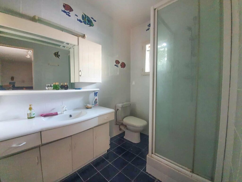 bathroom with white walls and standing shower
