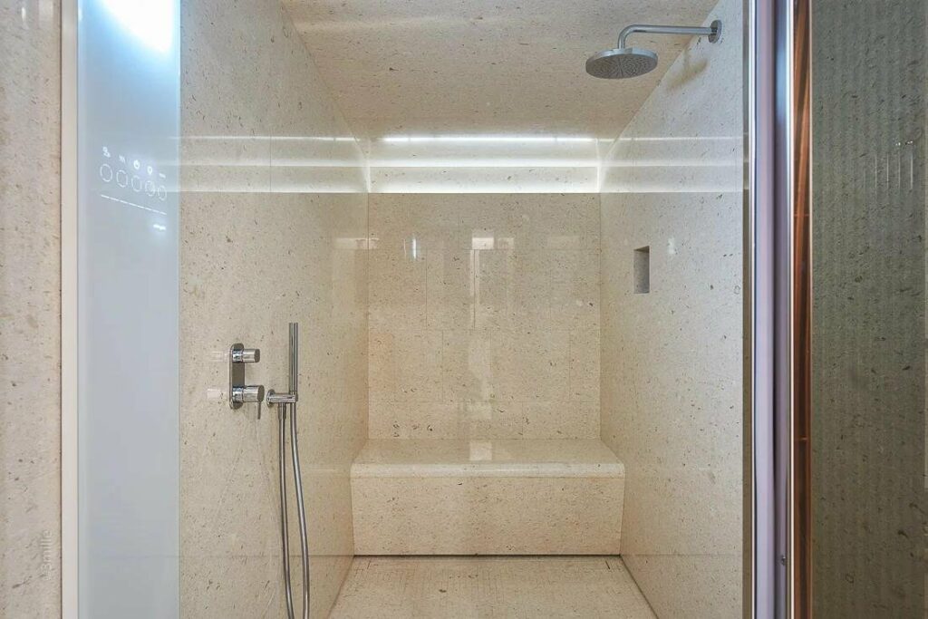 compact indoor sauna with cream colored walls and built in shower