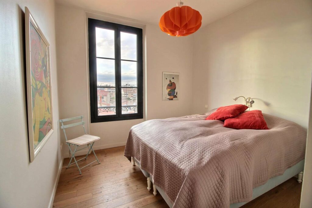bedroom with white colored bedding and orange pillows