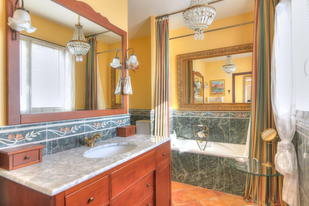 bathroom with green marble tile and large mirror