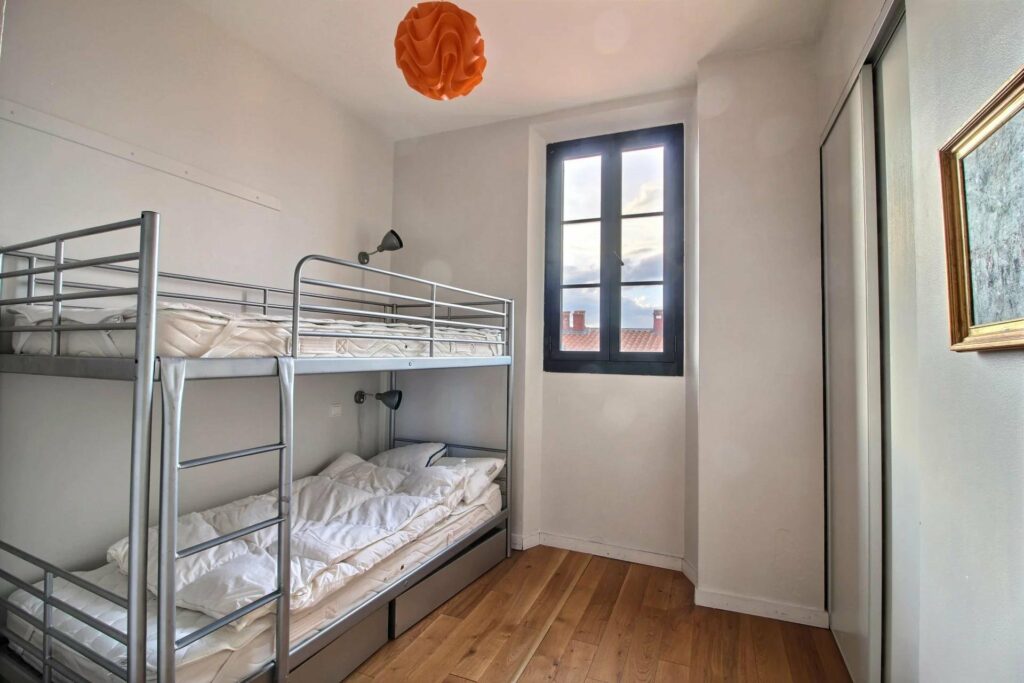 bedroom with bunk beds and orange light fixture next to window