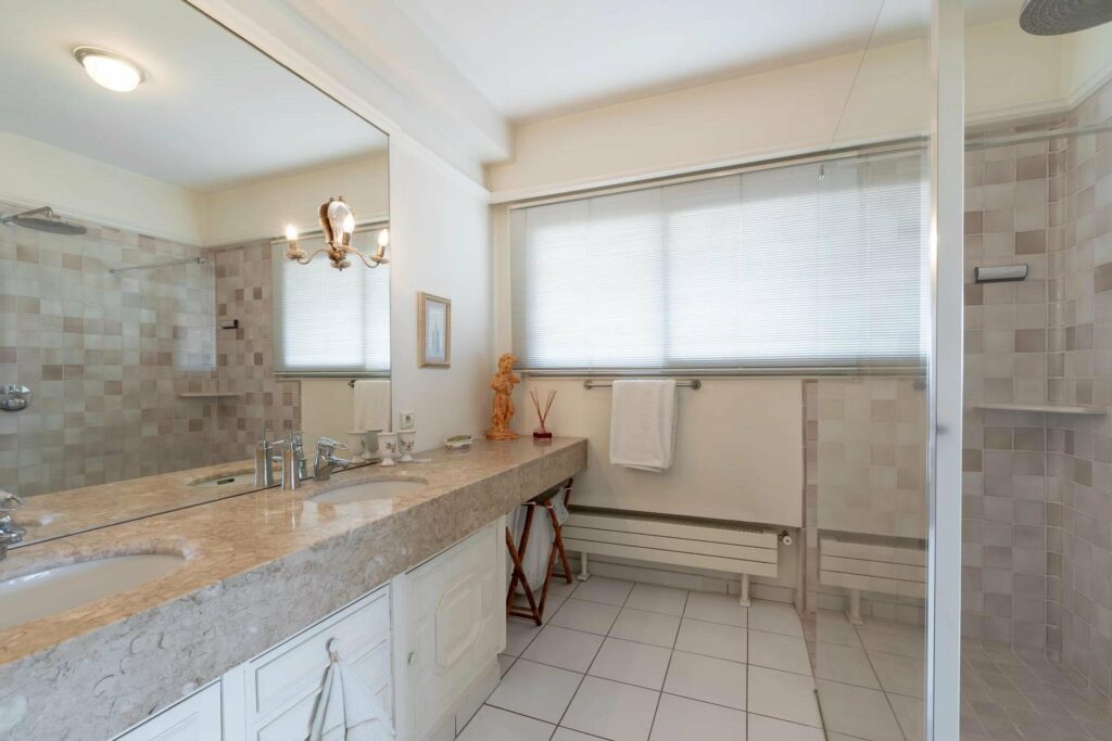 open bathroom with light grey counter top and beige tiling throughout