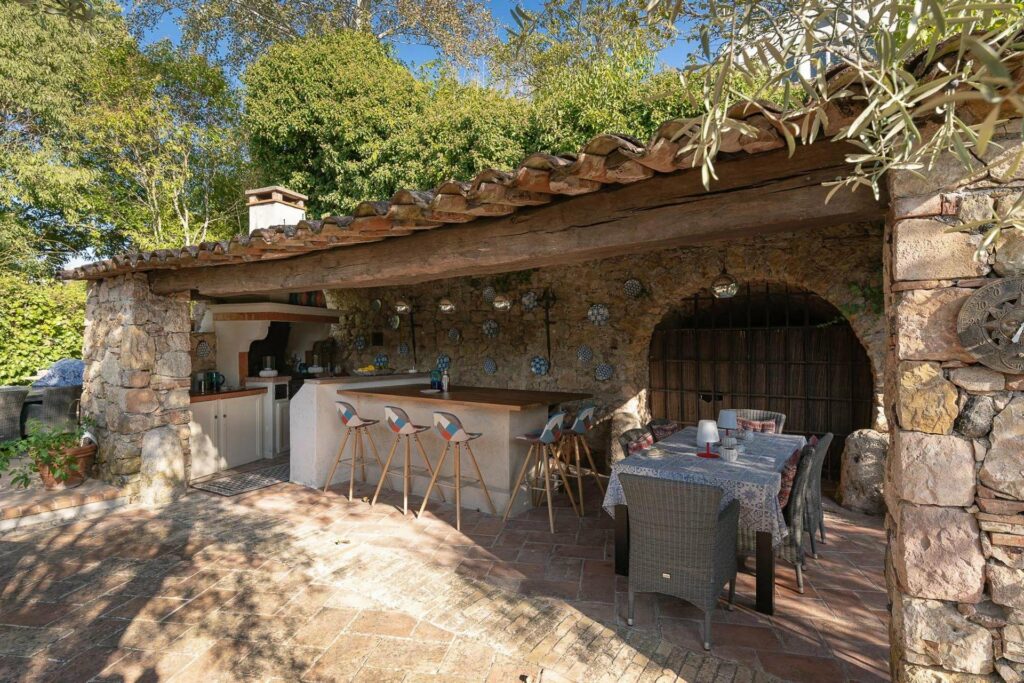 summer kitchen with with stone walls and outdoor tables
