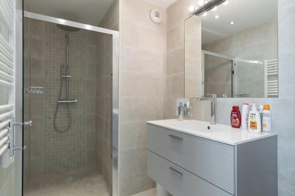 bathroom with grey tile walls and standing shower