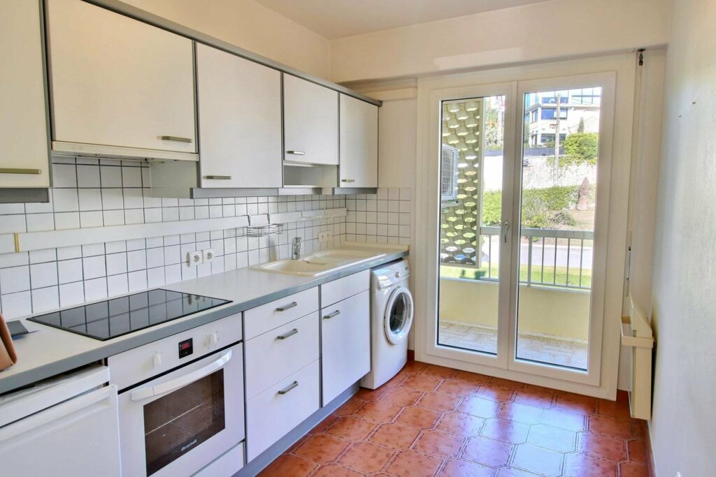 kitchen with white cabinets and sliding door access to balcony