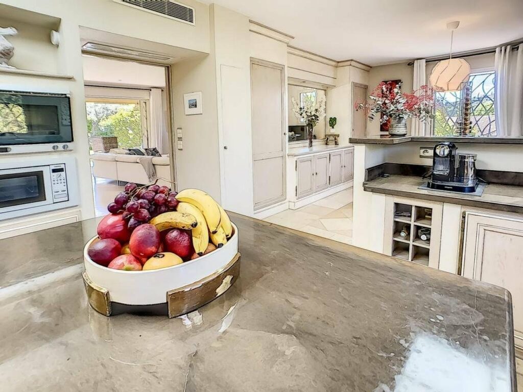 kitchen with colorful fruits in center of granite island