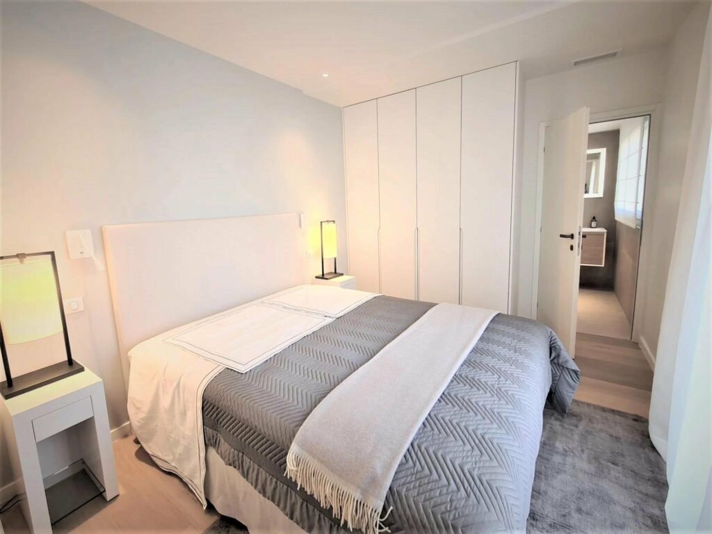 bedroom with light grey bedding in luxury apartment cannes