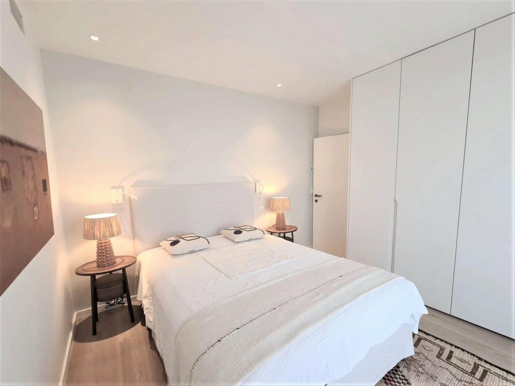 bedroom with white bedding and light blue wall