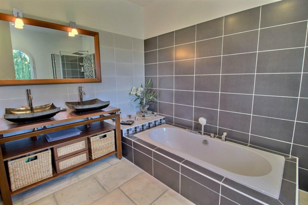 bathroom with grey tile wall and white bath tub at Montauroux villa