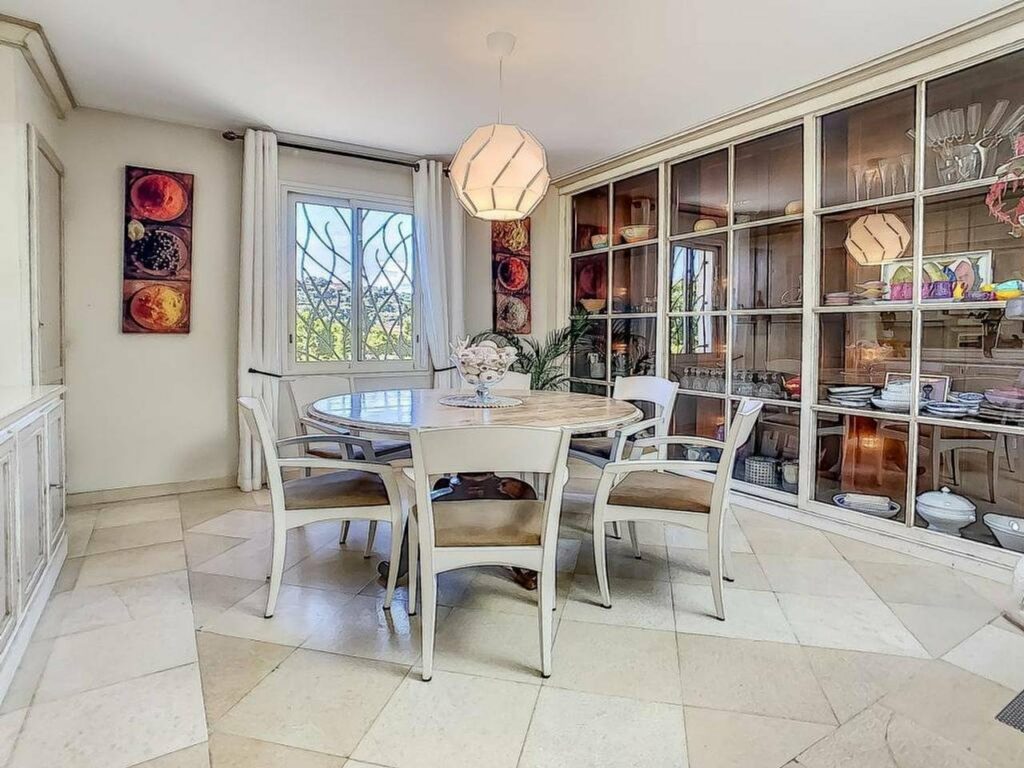 dining area with round white table and white tile floors with hanging round light fixture