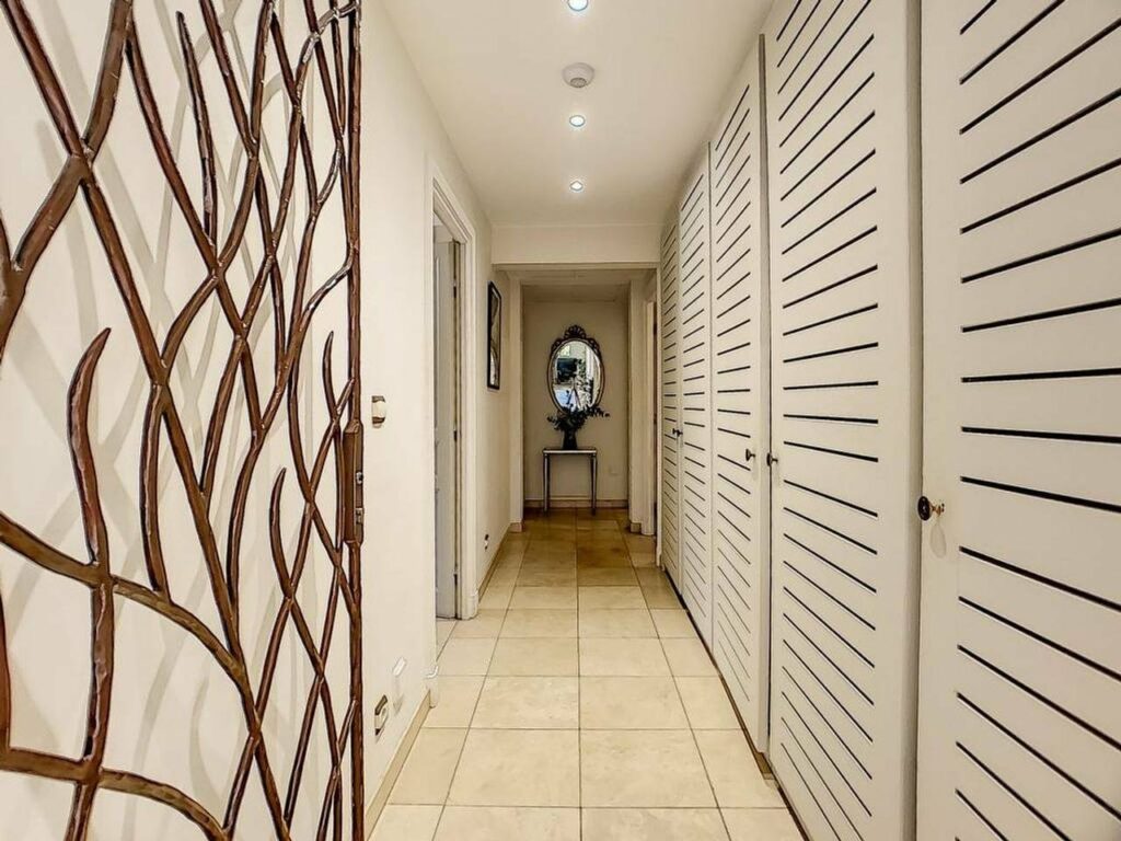 hallway with beige tile floors and white cabinets