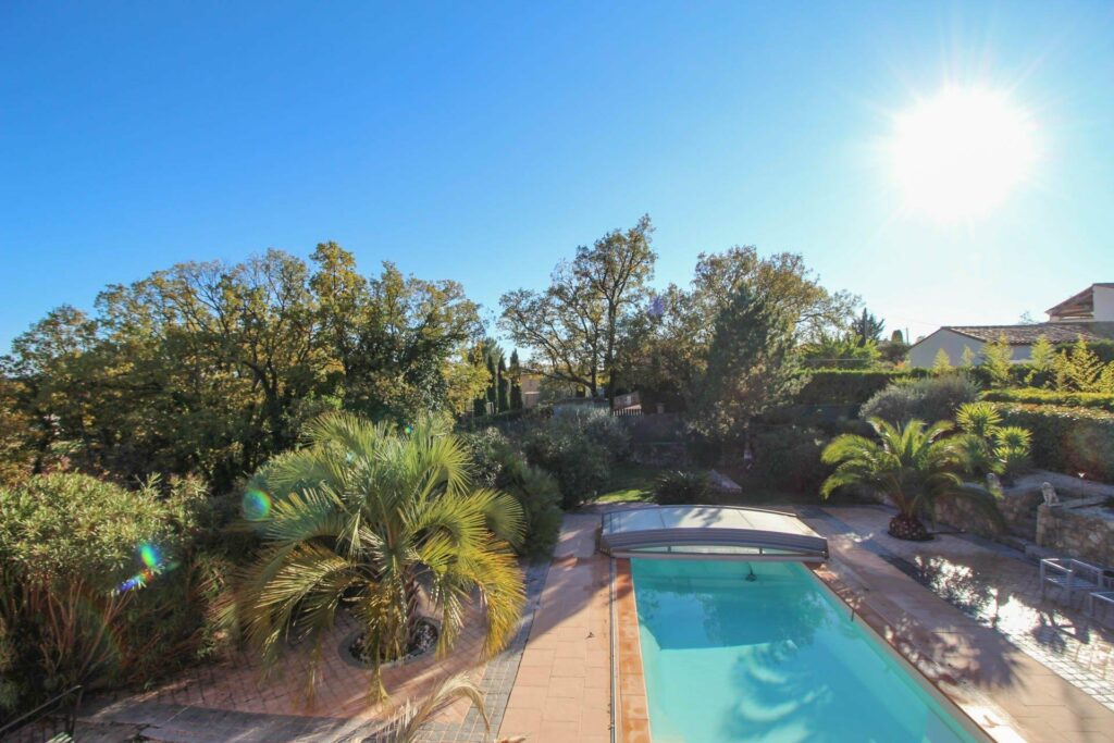 backyard with swimming pool and large trees surrounding the pool