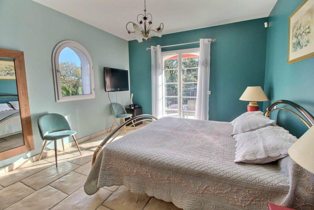 bedroom with blue walls and hanging chandelier