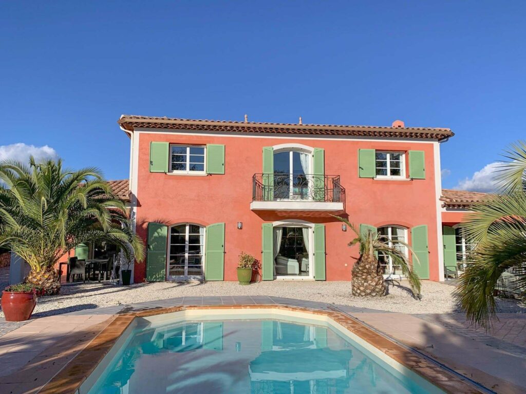 villa in he south of france with terracotta exterior and bright green shutters