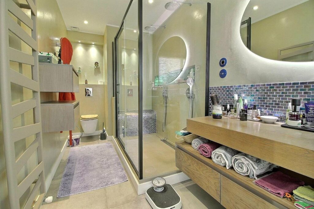 large open bathroom with glass standing shower and beige tile floors