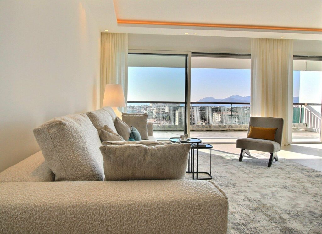 living room with beige couch next to large floor to ceiling windows with city view