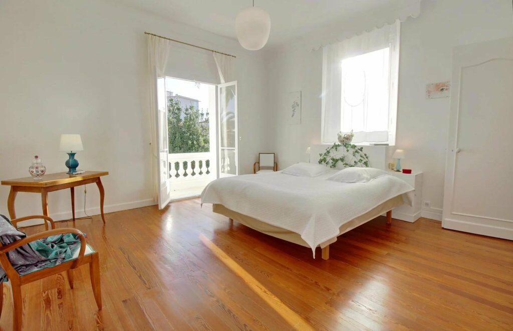 bedroom with white bed and wooden floors