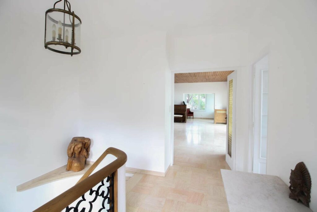 hallway with beige tile floors and high ceilings