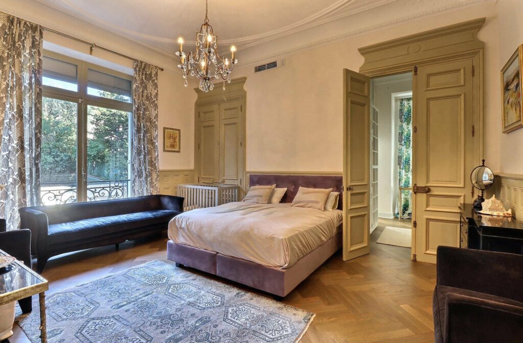 bedroom with queen size bed with violet bedding and grey rug