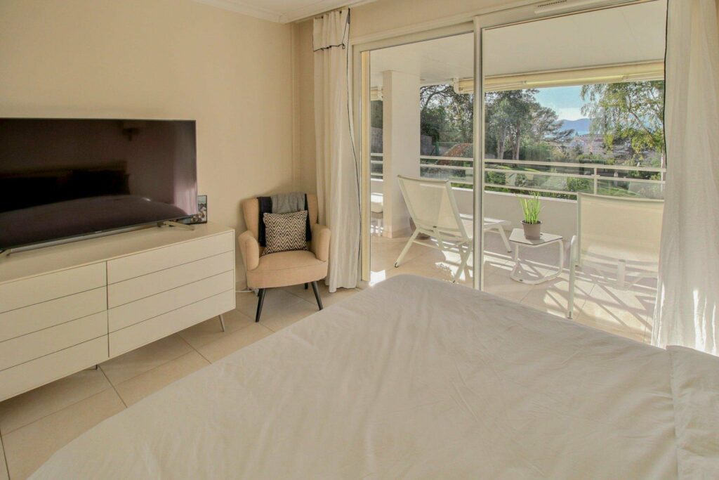 bedroom with white design and beige chair in corner
