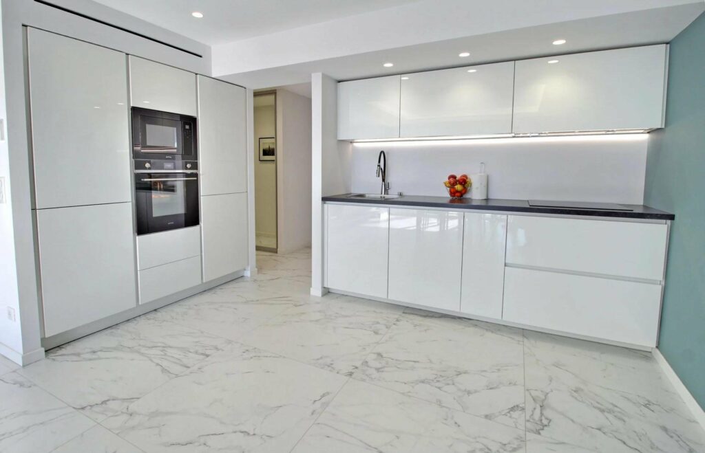 modern kitchen with white cabinets and white marble floors