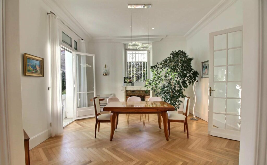 dining room in cannes home with large wooden table and large windows with garden view