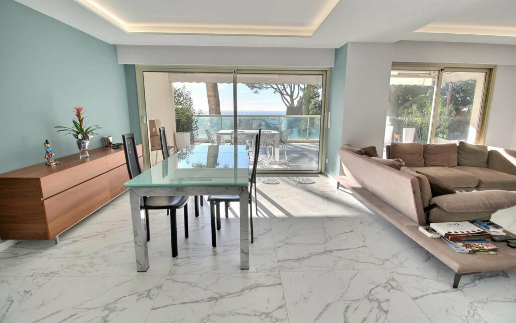 dining room with marble floors and glass table with large glass door access to terrace