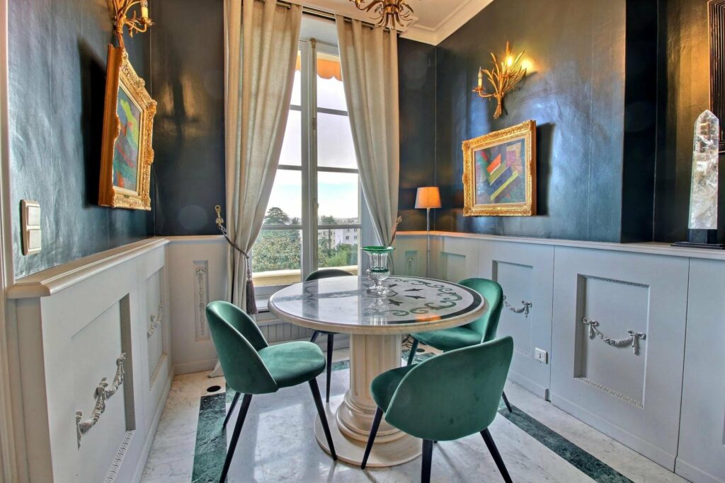 villa for sale in cannes with round glass table and green velvet chairs