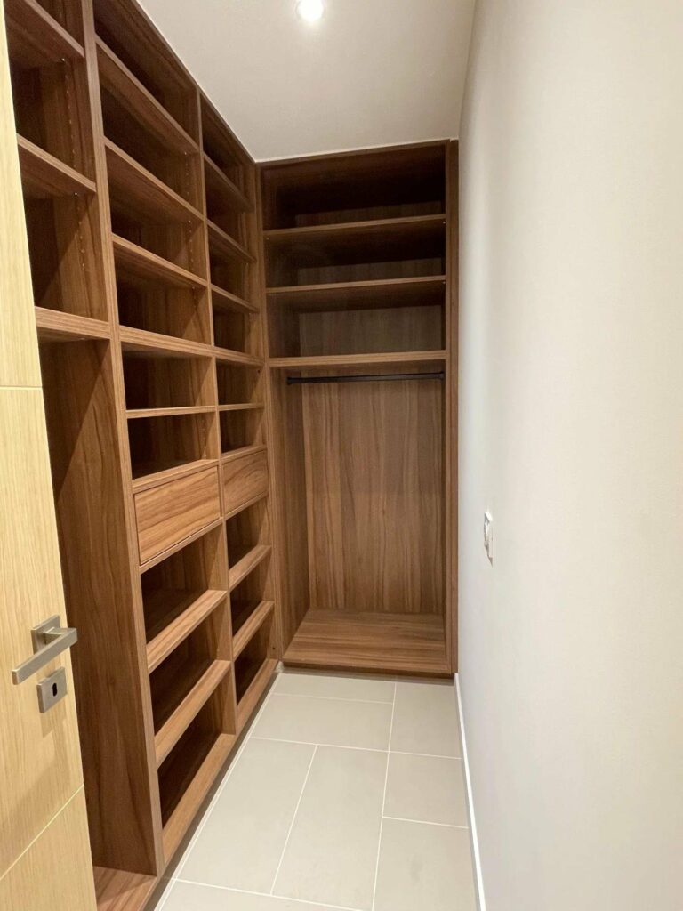 small walk in closet with wooden shelves