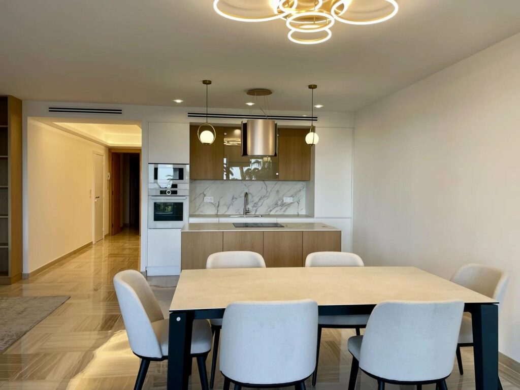 dining room with white dining table with view of kitchen