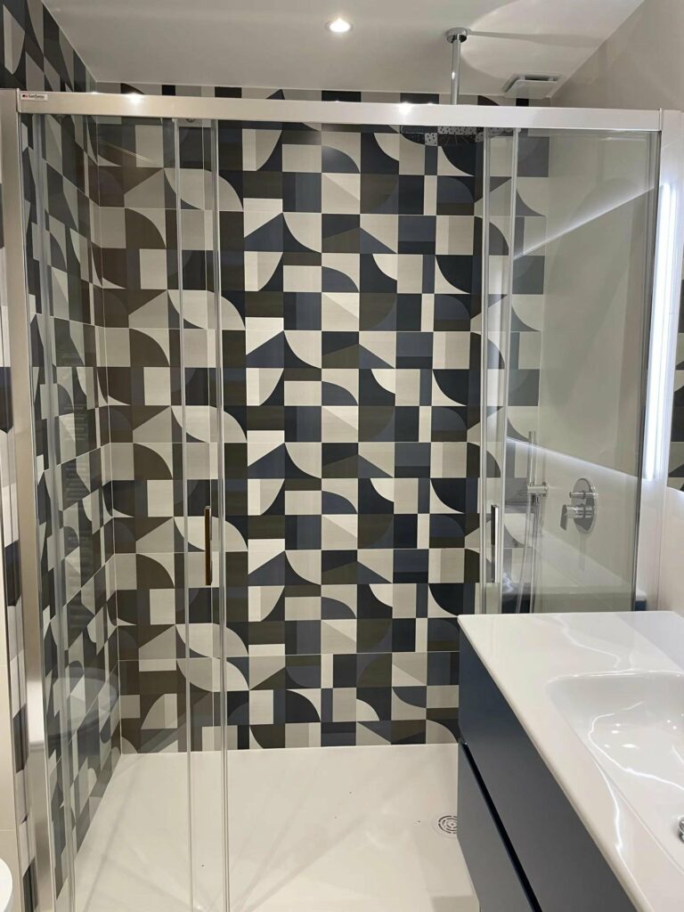 bathroom with grey and black tile design in shower