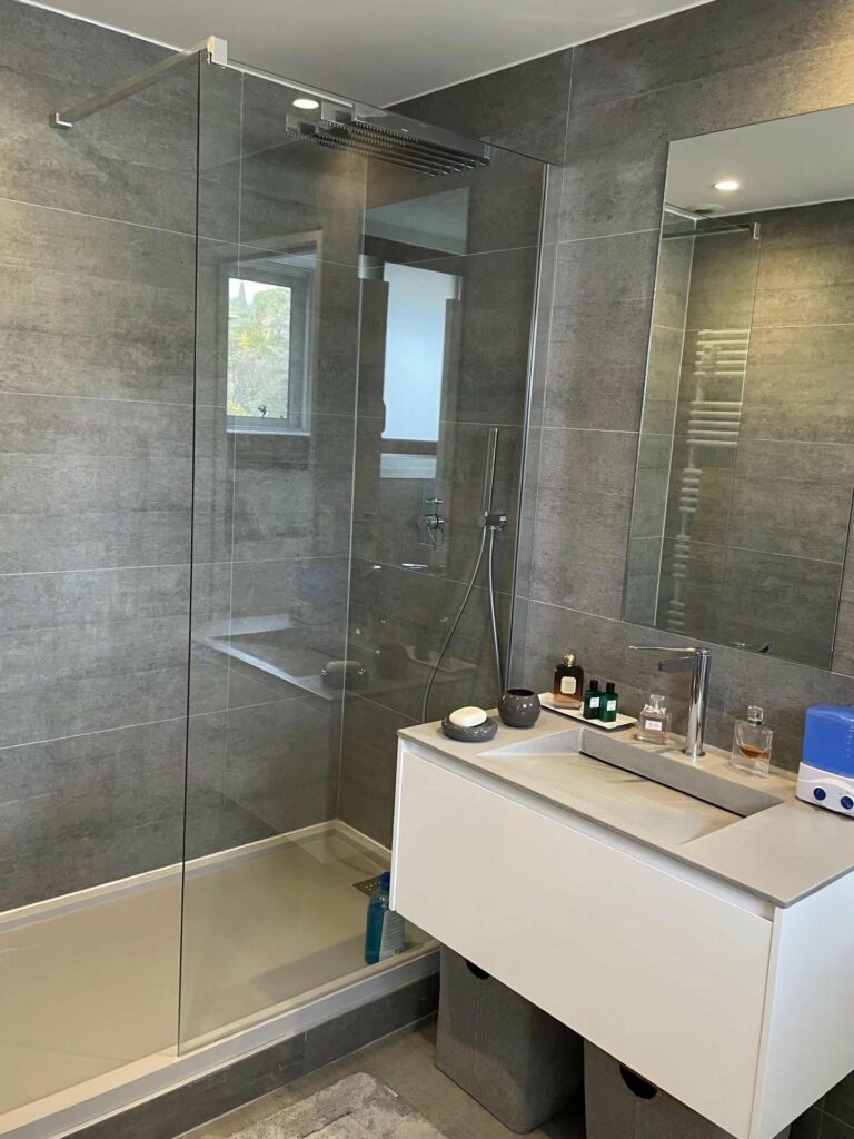 bathroom with grey tiling and large standing shower