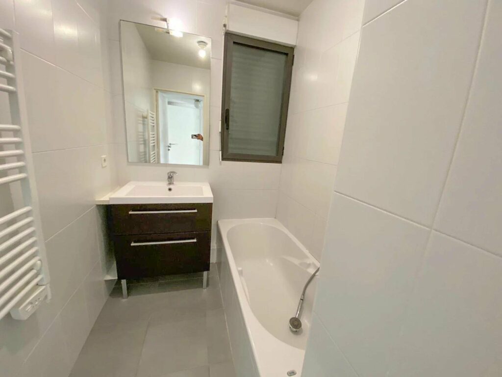 bathroom with white walls and white bath tub