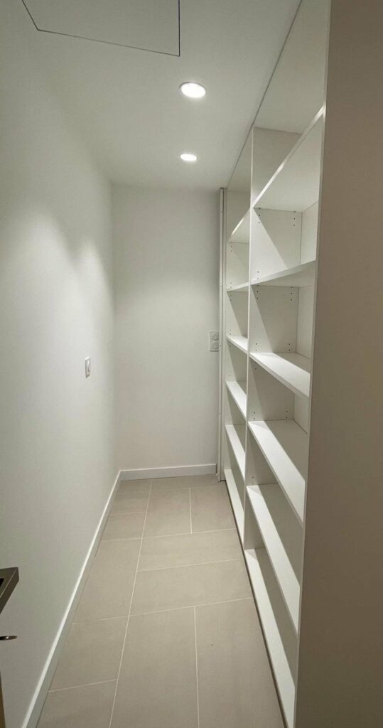 walk in closet with white shelving at cannes apartment